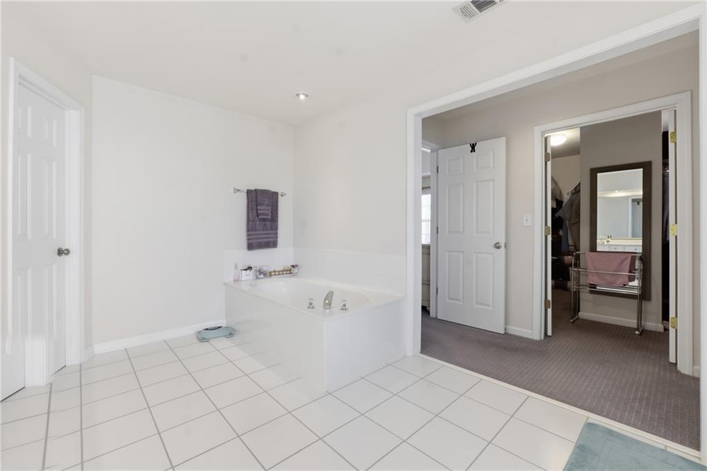 38 Crystal Downs Way Northeast Suwanee, GA 30024 - Photo 29 of 44 a spacious bathroom with a bathtub and mirror