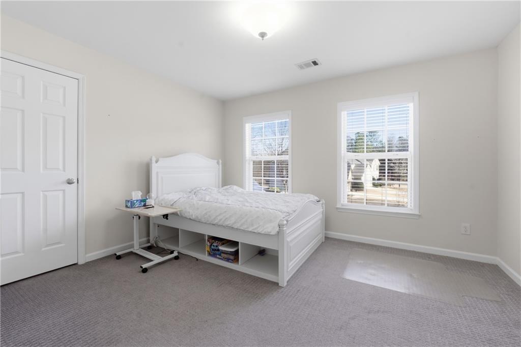 38 Crystal Downs Way Northeast Suwanee, GA 30024 - Photo 30 of 44 a spacious bedroom with a bed and a window