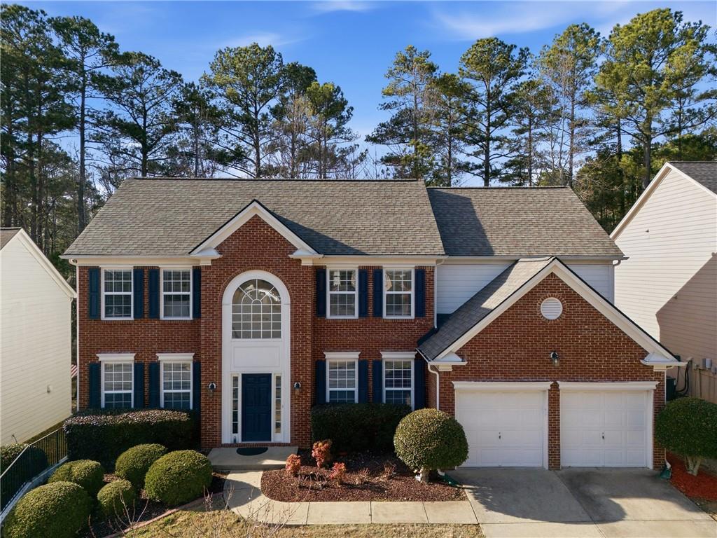 38 Crystal Downs Way Northeast Suwanee, GA 30024 - Photo 5 of 44 a front view of a house with a yard and garage