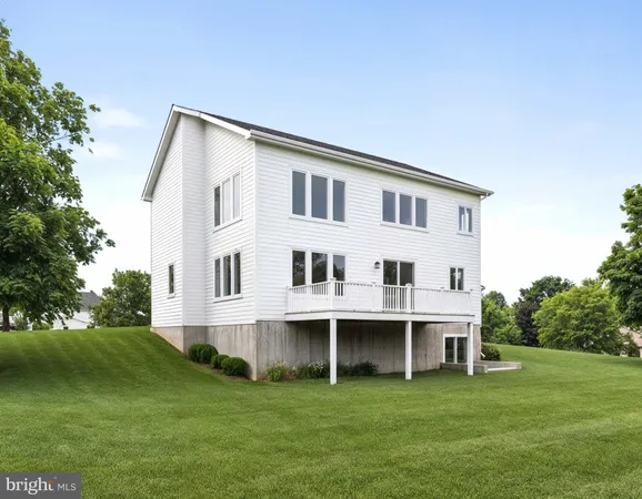 a view of a house with a big yard and large trees
