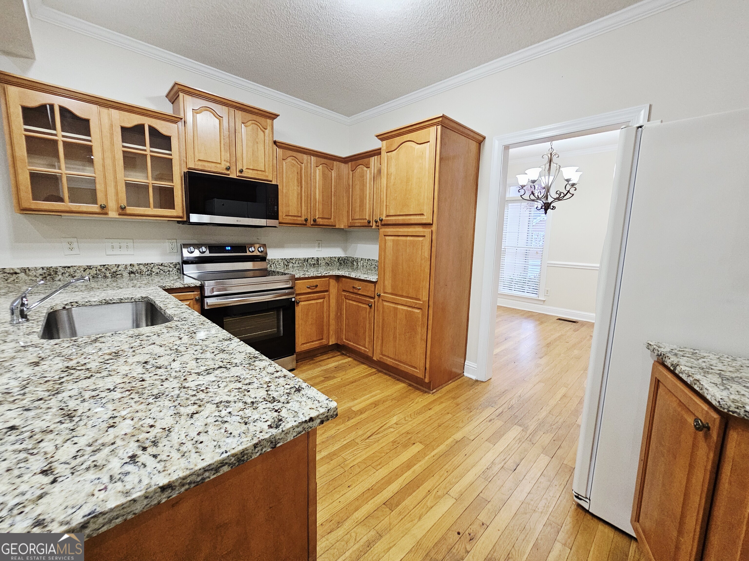122 High Ridge Drive Macon, GA 31220 - Photo 7 of 25 a kitchen with stainless steel appliances granite countertop a refrigerator a stove top oven a sink dishwasher and wooden floor