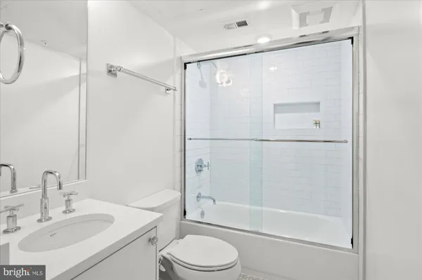 a bathroom with a bathtub shower sink vanity and toilet