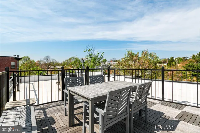 a view of a chairs and table on the roof deck