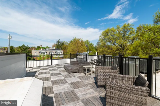 a view of a patio with lawn chairs floor to ceiling window and city view
