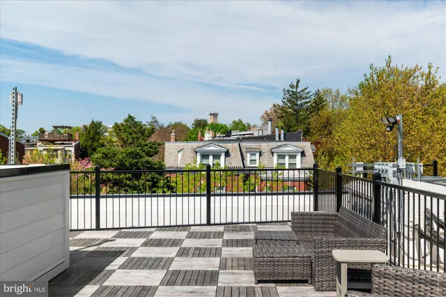 a view of a brick house with a small yard and wooden fence
