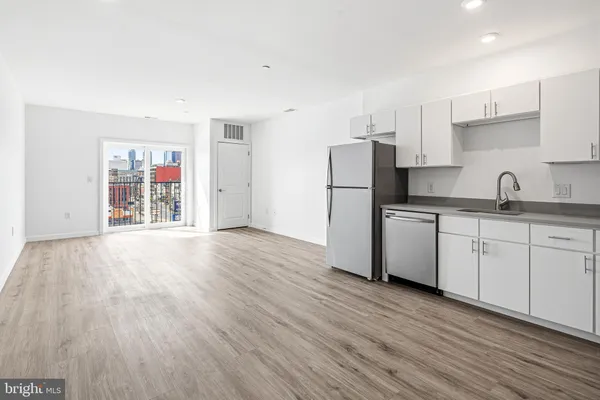 a kitchen with a refrigerator cabinets and wooden floor