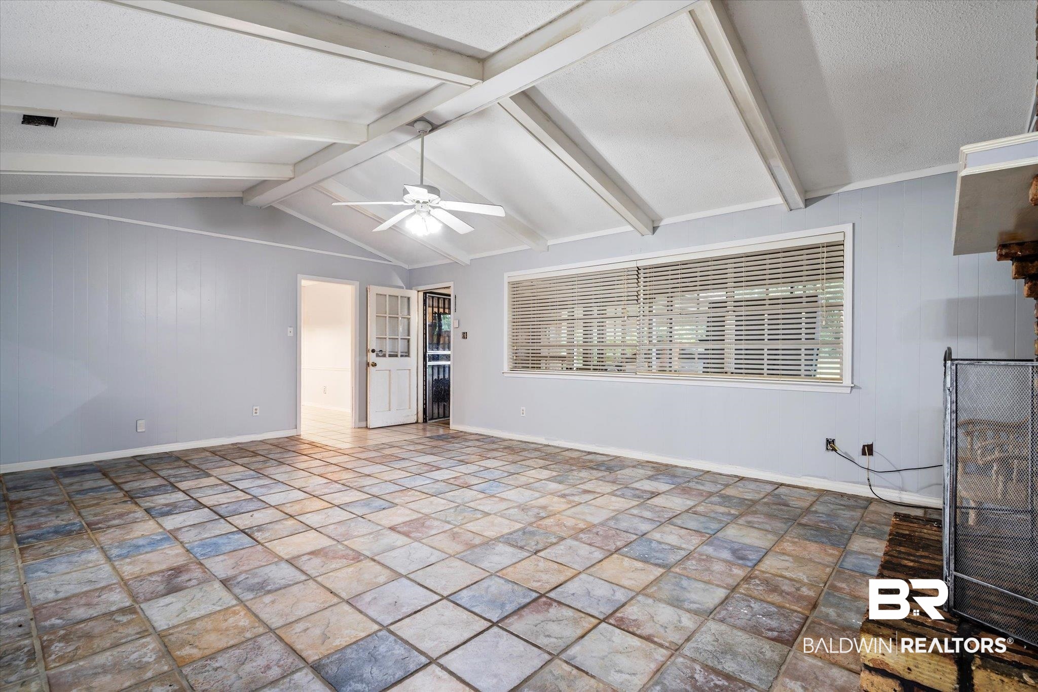 6657 Hounds Run South Mobile, AL 36608 - Photo 7 of 20 Unfurnished living room with ceiling fan, vaulted ceiling with beams, and a textured ceiling