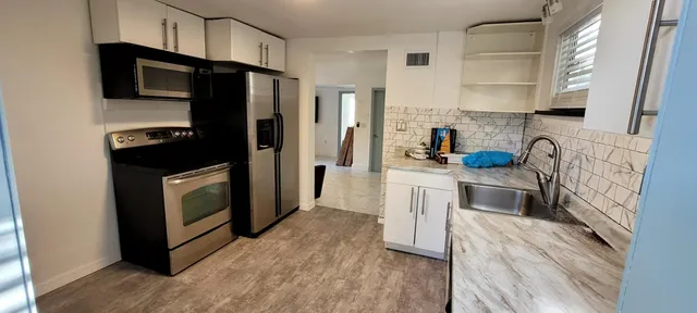 a kitchen with a sink a refrigerator and window
