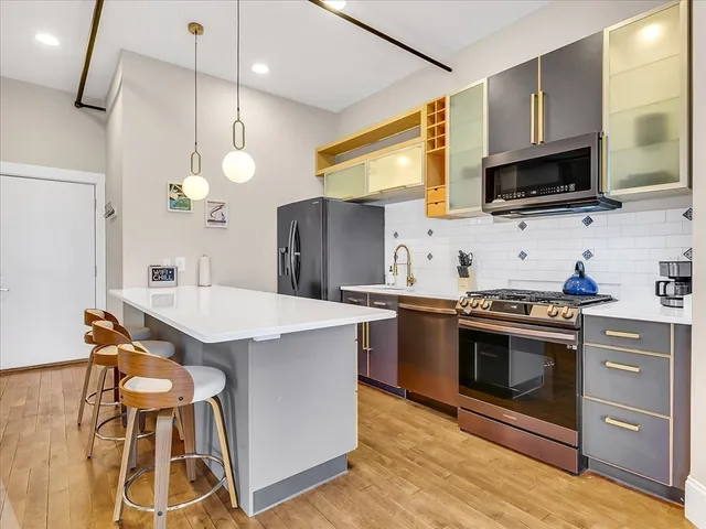 a kitchen with stainless steel appliances a stove a sink and a microwave