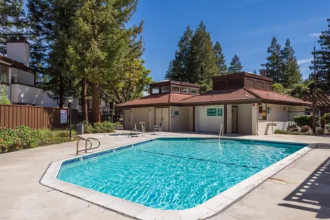 a front view of house with yard and trees in the background