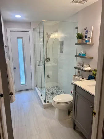 a bathroom with a granite countertop sink toilet and shower