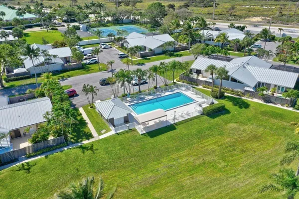 an aerial view of residential houses with outdoor space and parking