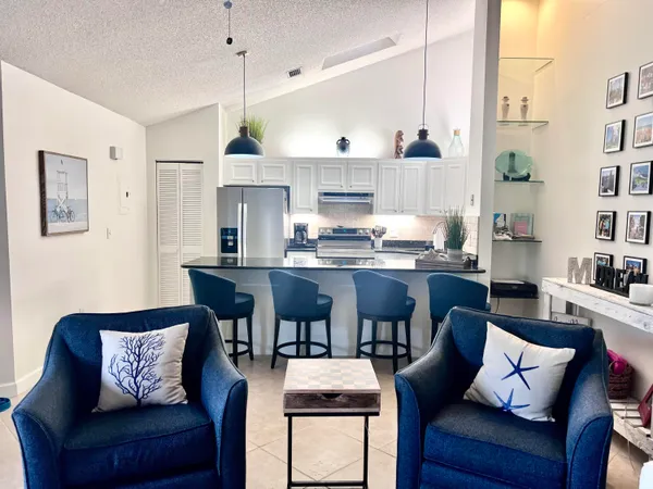 a living room with stainless steel appliances granite countertop furniture and a kitchen view