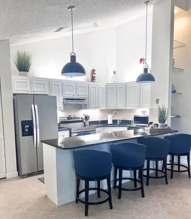 a kitchen with stainless steel appliances granite countertop a sink a stove and refrigerator