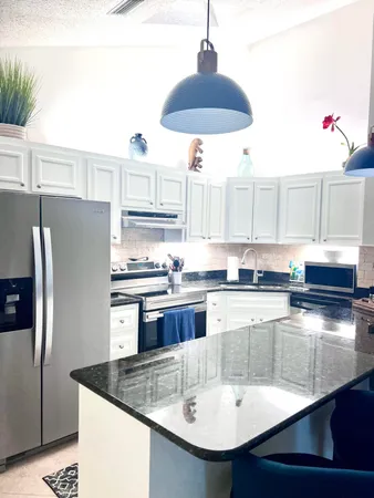 a kitchen with stainless steel appliances granite countertop a sink a stove and refrigerator