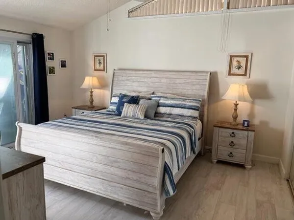 a bedroom with a bed and a lamp on the dresser