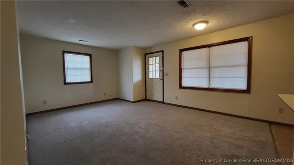 an empty room with windows and closet