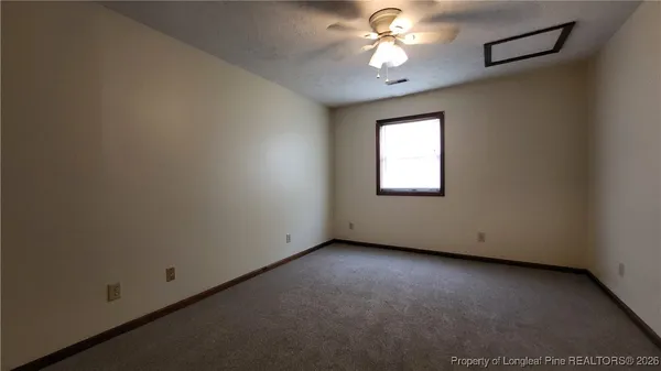 an empty room with a window and a fan