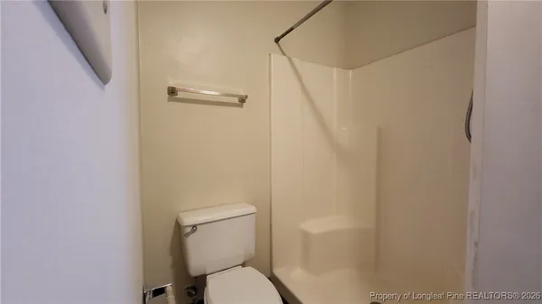 a bathroom with a toilet and a shower