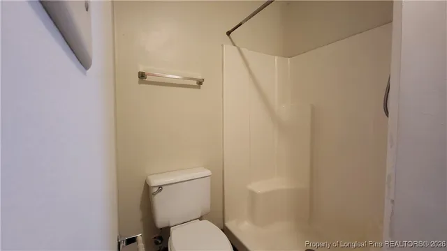 a bathroom with a toilet and a shower