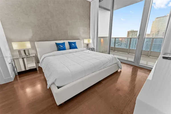 a large bed sitting in a bedroom next to a large window