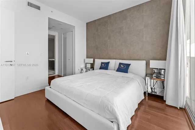 a bedroom with a bed and a large window