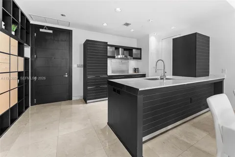 a kitchen with stainless steel appliances kitchen island a sink refrigerator and cabinets