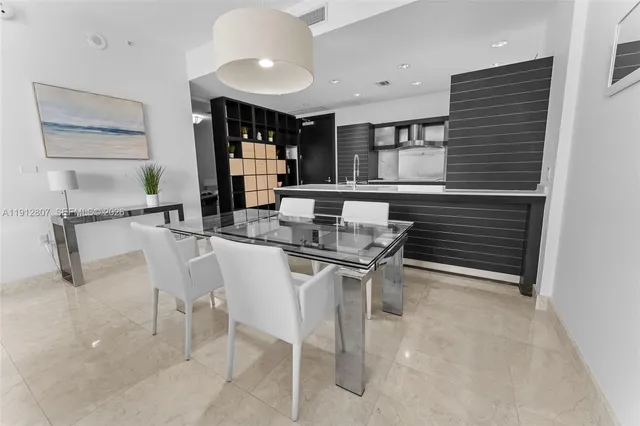 a kitchen with a table chairs and a refrigerator