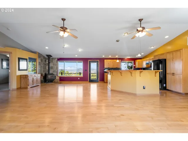 a view interior of a kitchen and a refrigerator with wooden floor