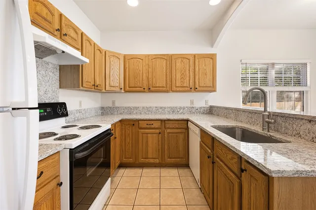 a kitchen with a sink stove top oven and cabinets