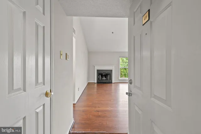 a view of a hallway with wooden floor and a fireplace