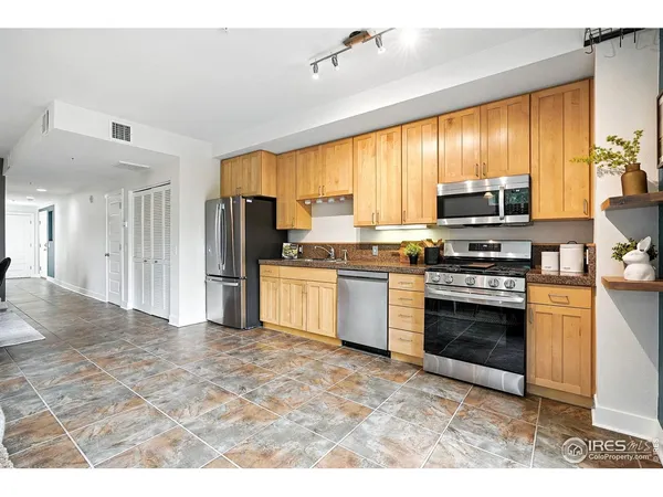 a kitchen with stainless steel appliances granite countertop a stove a sink and a refrigerator