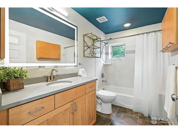 a bathroom with a granite countertop sink mirror vanity and toilet