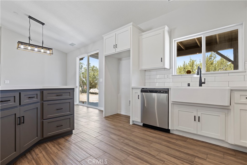 14586 Ash Hesperia, CA 92345 - Photo 13 of 30 a kitchen with stainless steel appliances white cabinets and wooden floors
