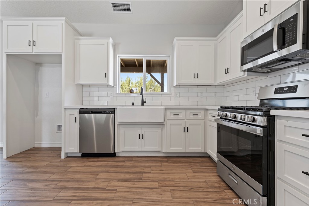 14586 Ash Hesperia, CA 92345 - Photo 14 of 30 a kitchen with stainless steel appliances a stove a sink and a microwave