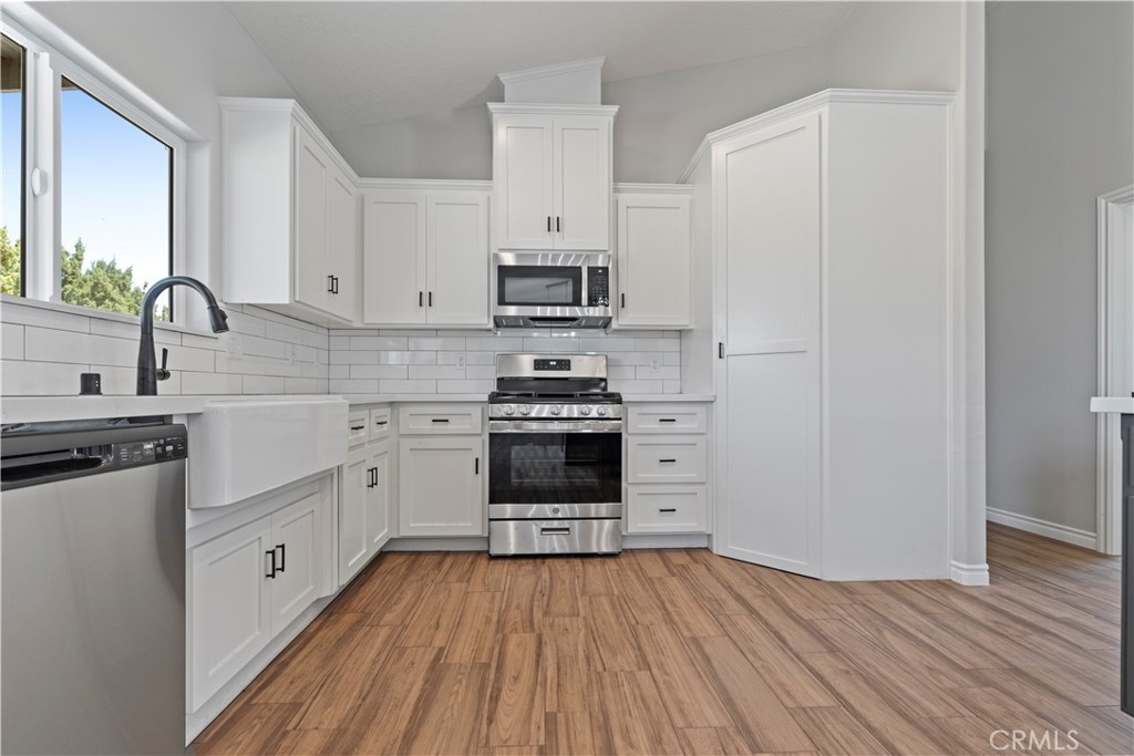 14586 Ash Hesperia, CA 92345 - Photo 15 of 30 a kitchen with stainless steel appliances a stove a sink and a refrigerator