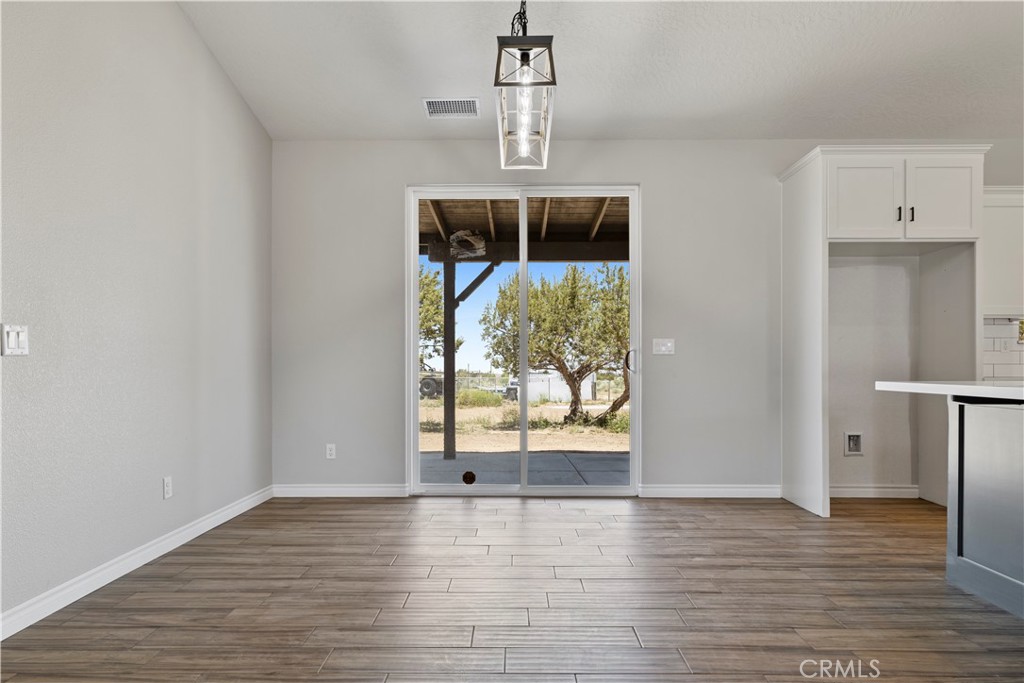 14586 Ash Hesperia, CA 92345 - Photo 7 of 30 a view of an empty room with wooden floor and a window