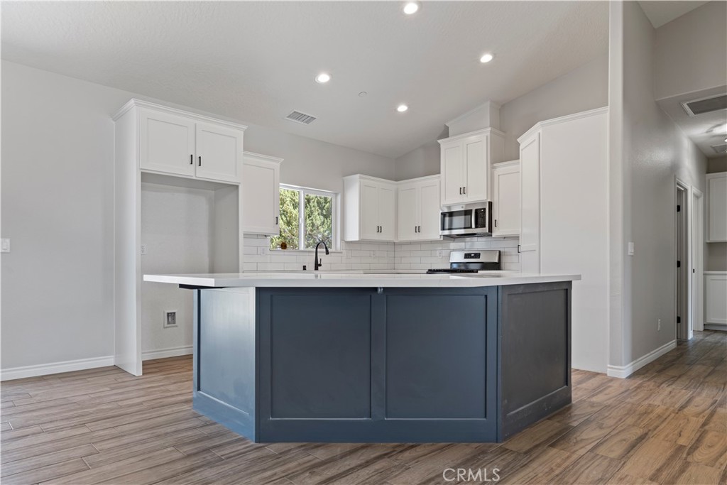 14586 Ash Hesperia, CA 92345 - Photo 10 of 30 a kitchen with stainless steel appliances a sink cabinets and wooden floor