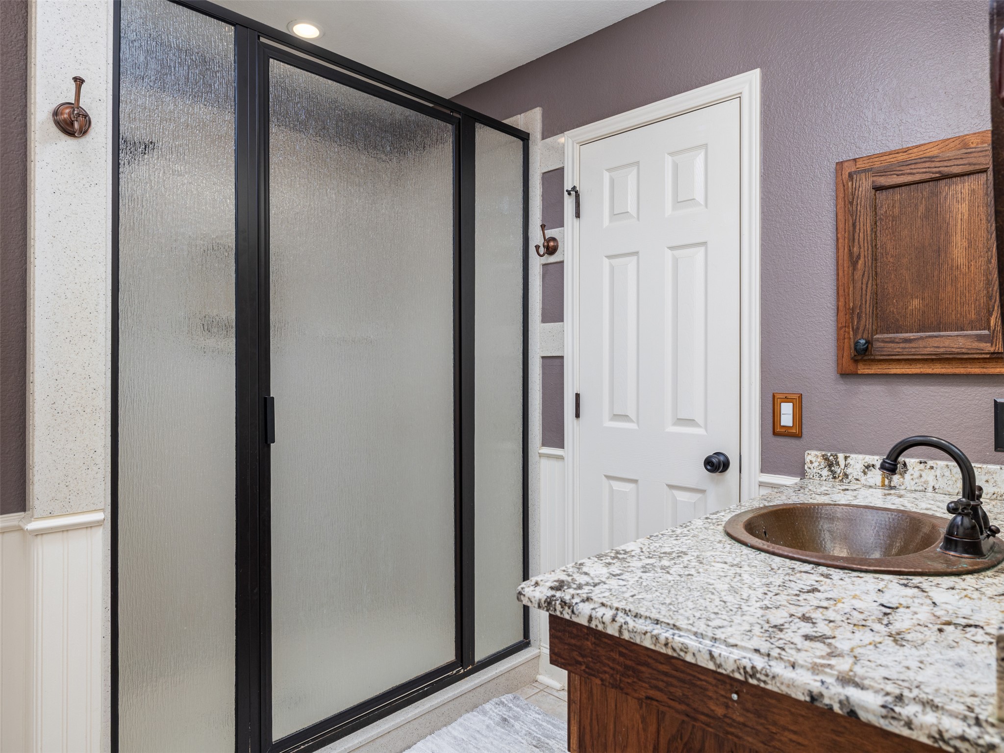 208 South Buffalo Pass Georgetown, TX 78633 - Photo 12 of 28 Full bathroom with a stall shower, vanity, a textured wall, and a wainscoted wall
