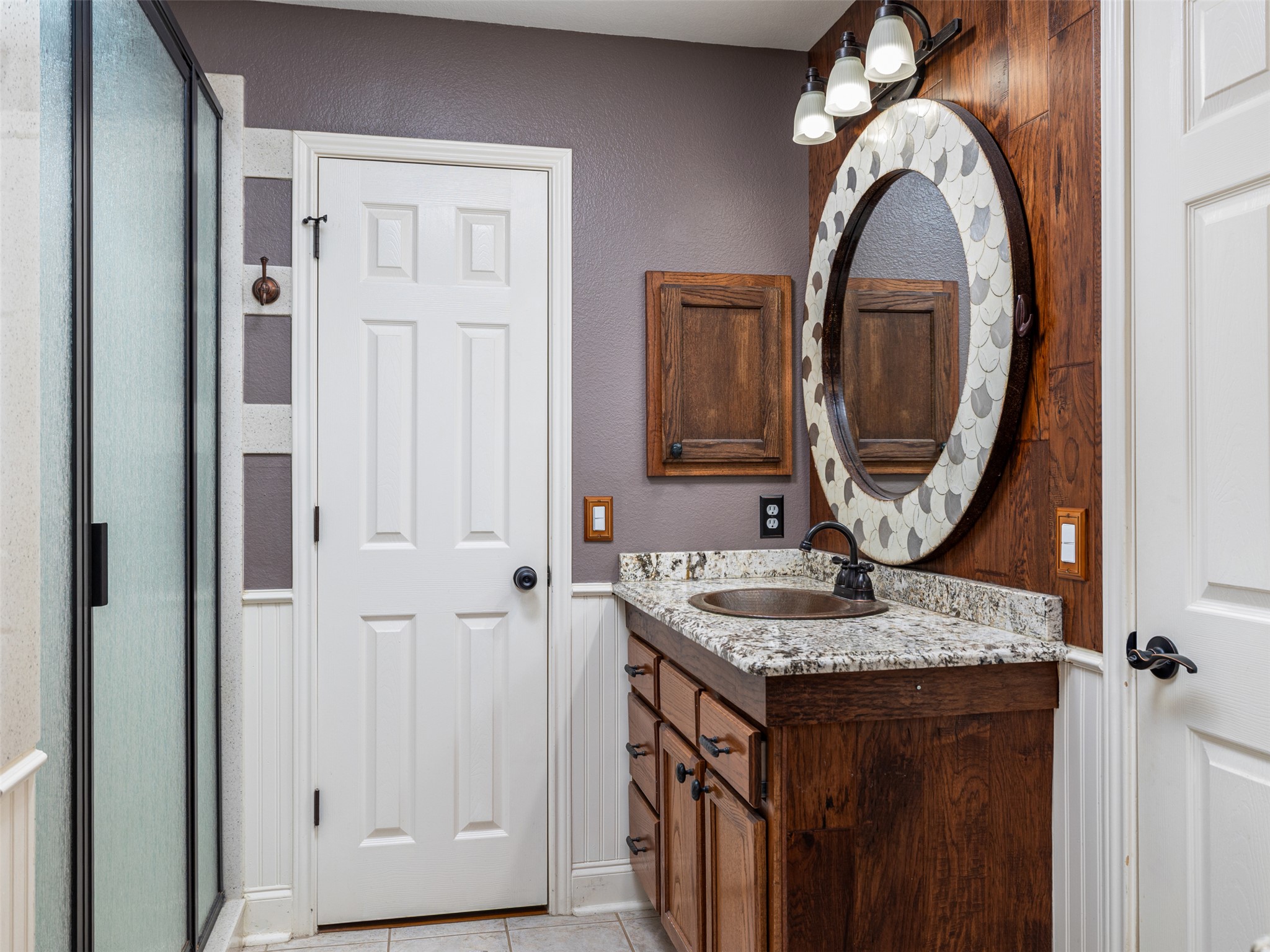 208 South Buffalo Pass Georgetown, TX 78633 - Photo 14 of 28 Full bath featuring split dual vanities, wainscoting, a shower stall, and light tile patterned floors