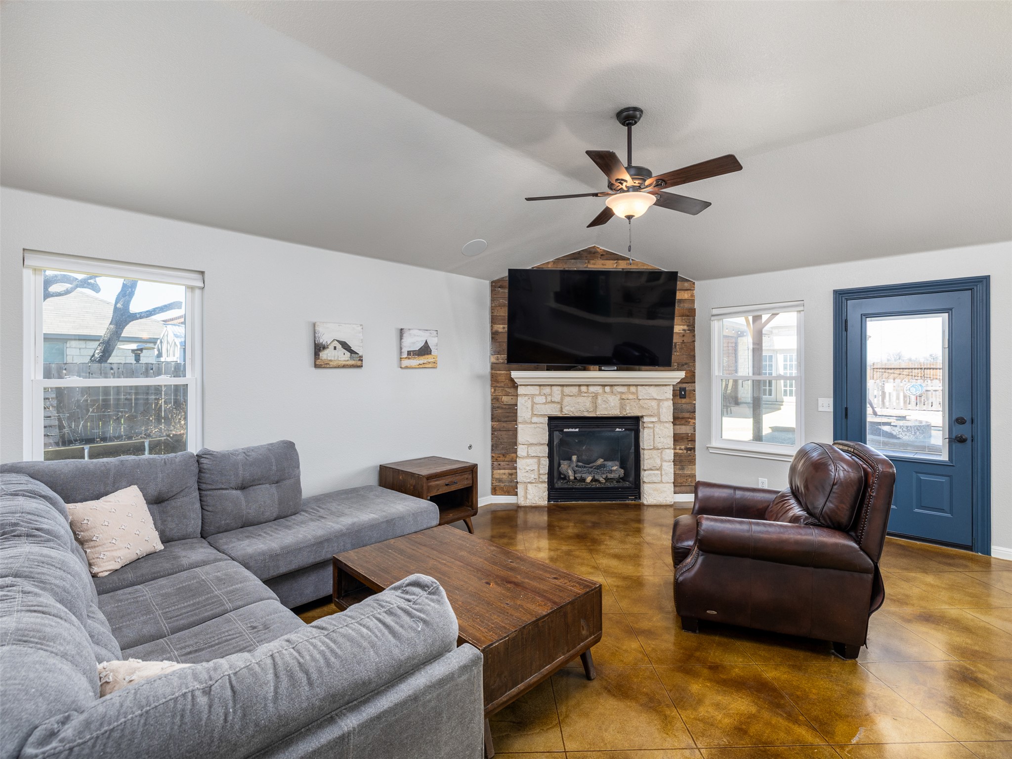 208 South Buffalo Pass Georgetown, TX 78633 - Photo 5 of 28 Living room with a fireplace, vaulted ceiling, finished concrete flooring, and ceiling fan