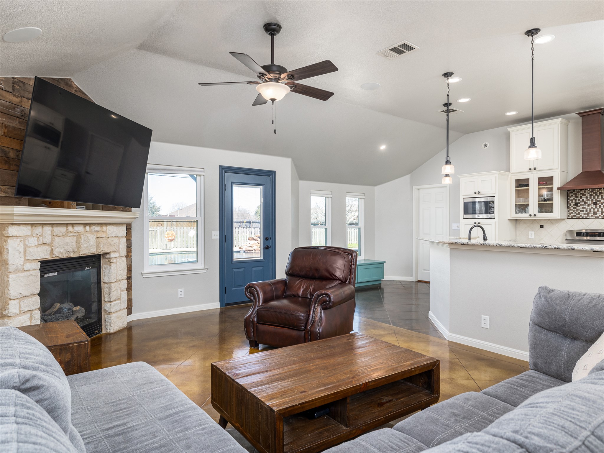 208 South Buffalo Pass Georgetown, TX 78633 - Photo 6 of 28 Living area featuring finished concrete floors, a stone fireplace, healthy amount of natural light, and ceiling fan