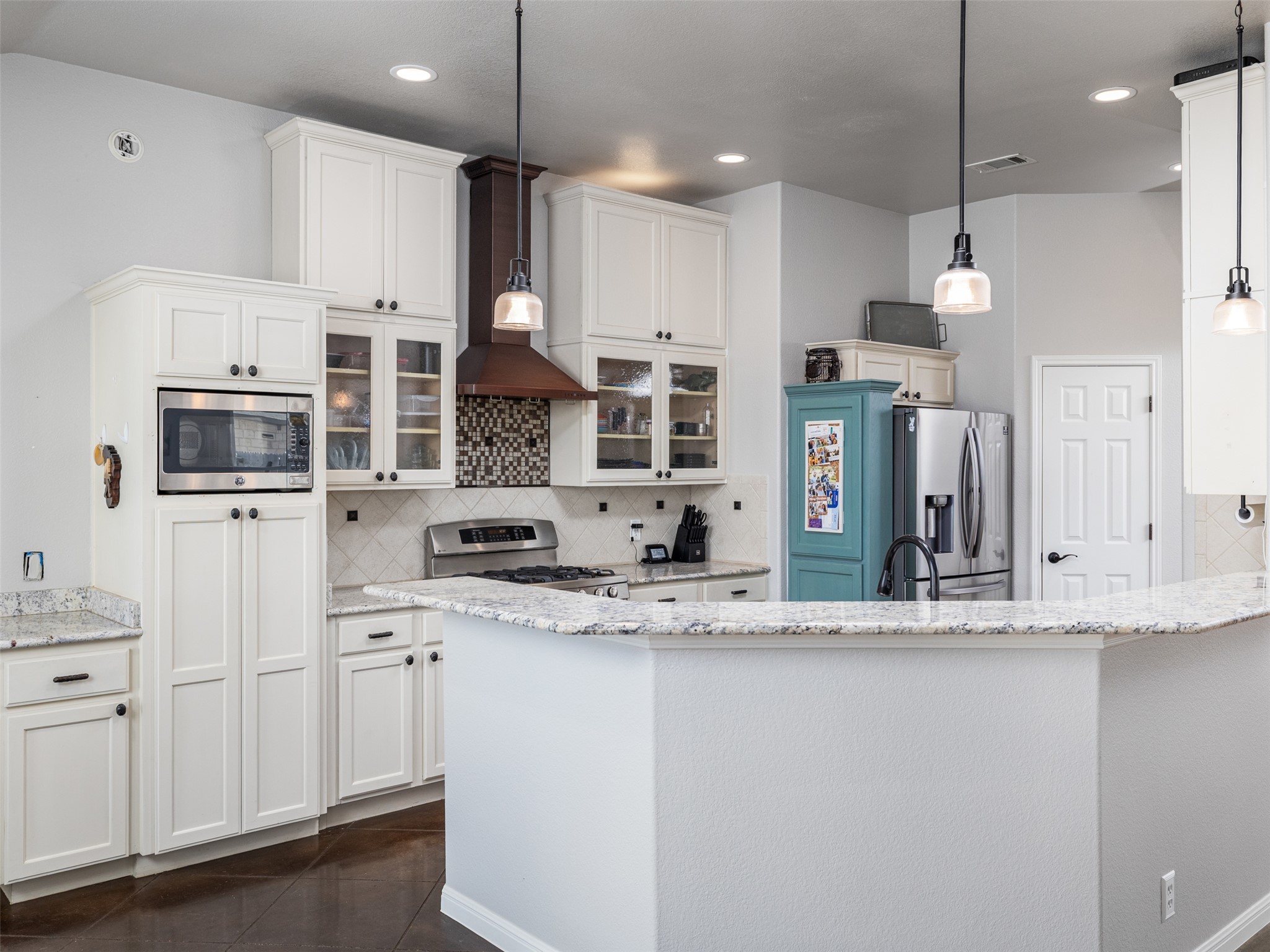 208 South Buffalo Pass Georgetown, TX 78633 - Photo 7 of 28 Kitchen with light stone countertops, glass fronted cabinets, tasteful backsplash, and stainless steel appliances