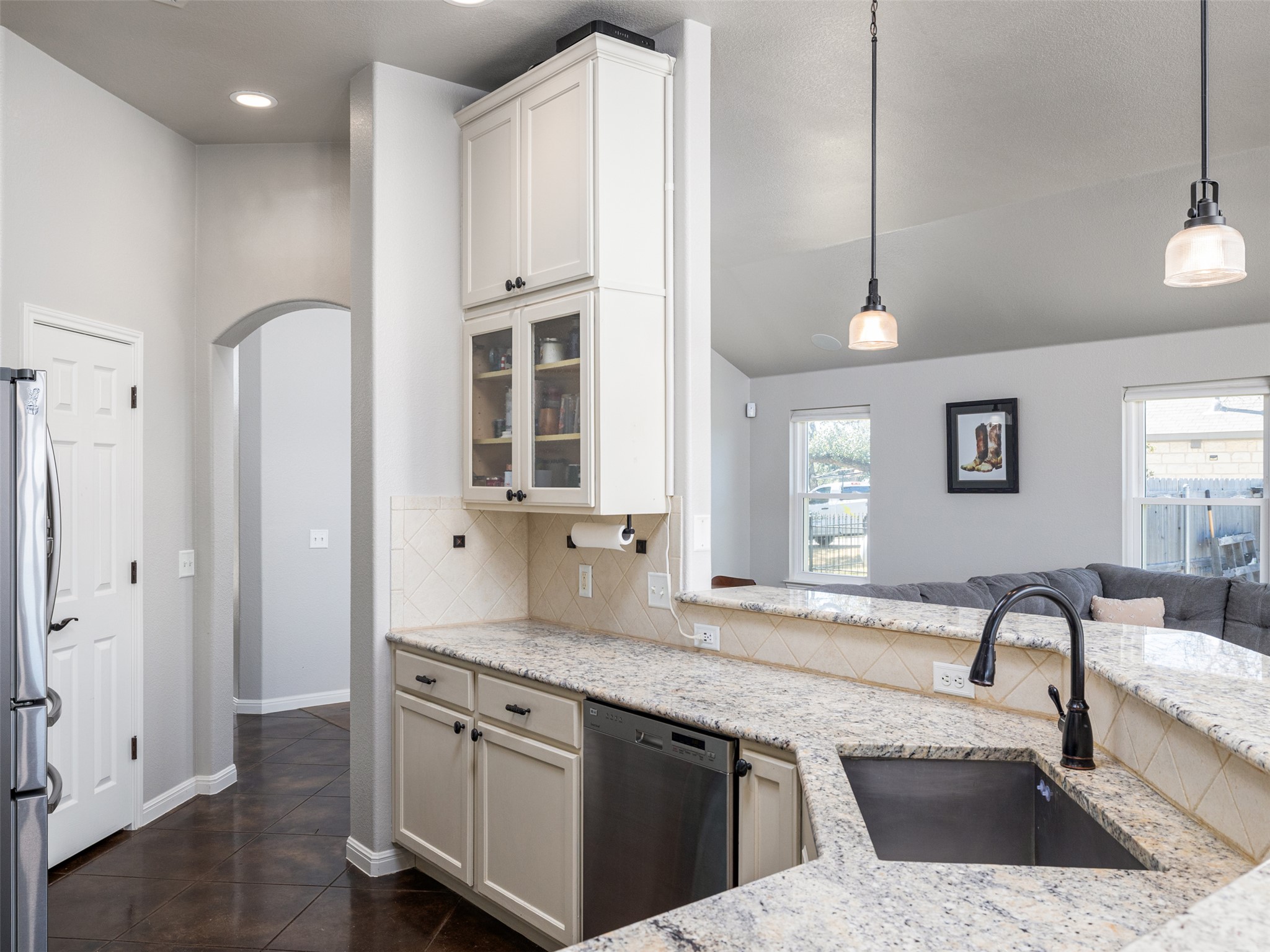 208 South Buffalo Pass Georgetown, TX 78633 - Photo 28 of 28 Kitchen featuring arched walkways, open floor plan, pendant lighting, stainless steel appliances, and light stone countertops