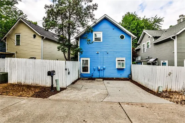 a view of a house with a yard and wooden fence