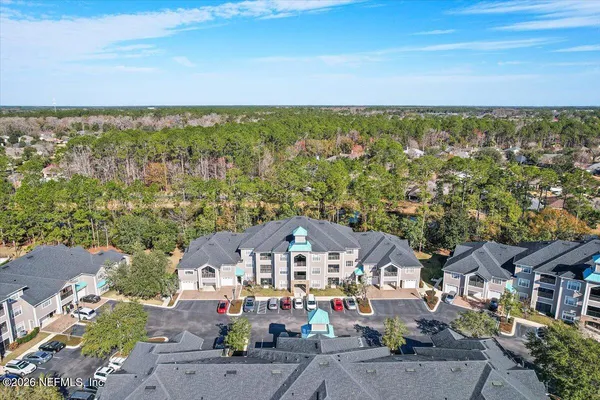 an aerial view of residential house with outdoor space and trees all around