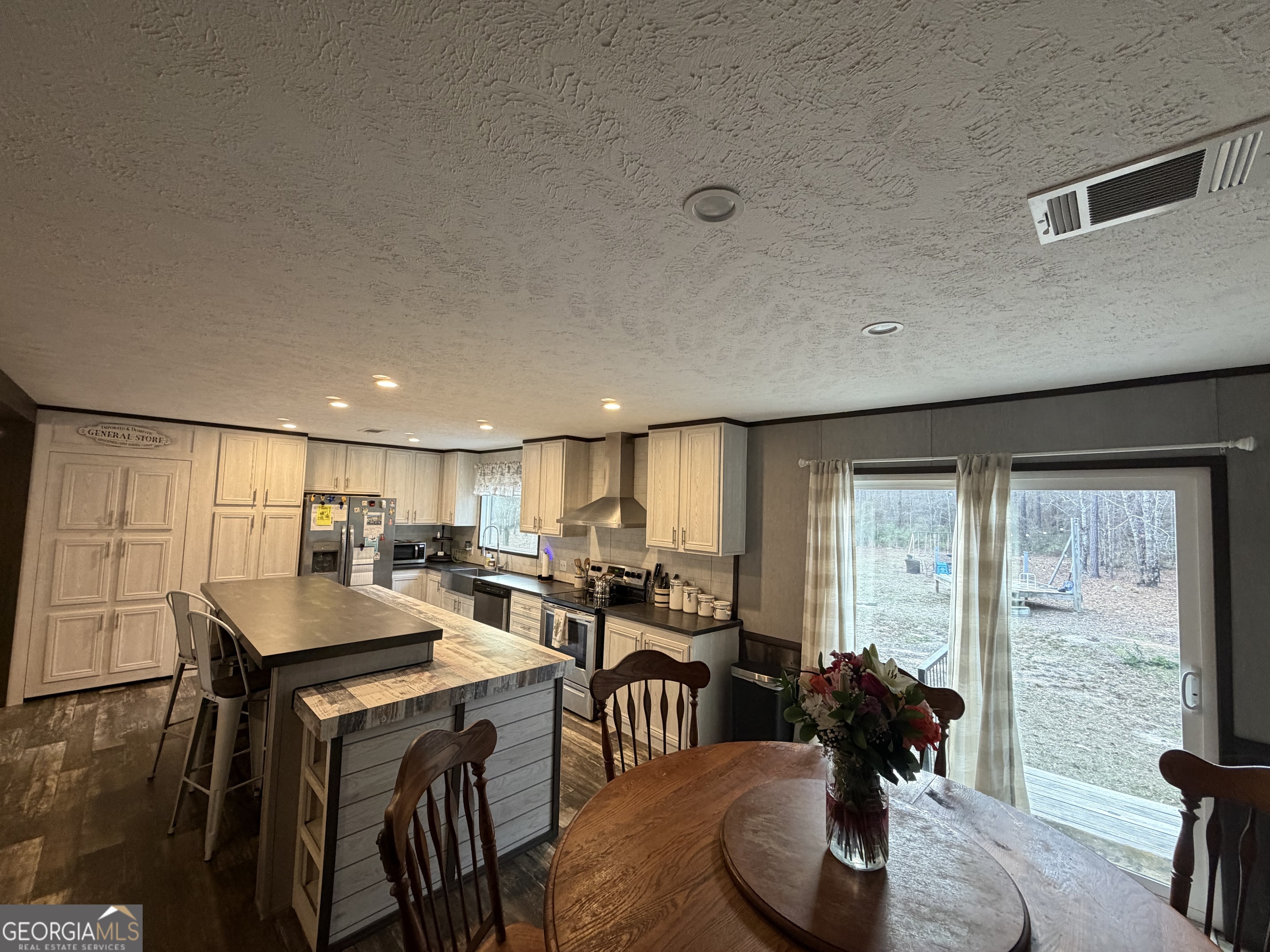 2601 New Evergreen Church Road Cadwell, GA 31009 - Photo 8 of 30 a kitchen with a dining table chairs and refrigerator