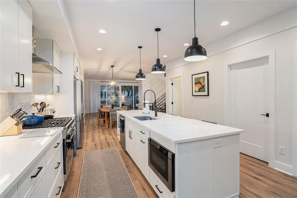 1649 Overlook Way Northwest Atlanta, GA 30324 - Photo 11 of 29 a large kitchen with kitchen island a stove a sink a refrigerator and a dining table with wooden floor