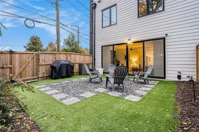 a view of a backyard with table and chairs potted plants and wooden fence