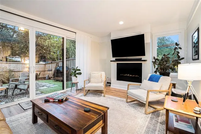 a living room with furniture flat screen tv and a large window
